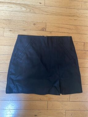 Olivaceous black faux leather mini skirt. Two front pockets. Zipper in back. Sm.